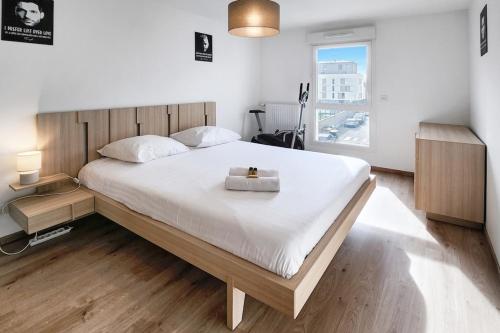 - une chambre avec un grand lit blanc et une boîte dans l'établissement Pixell Grand Lyon, à Villeurbanne