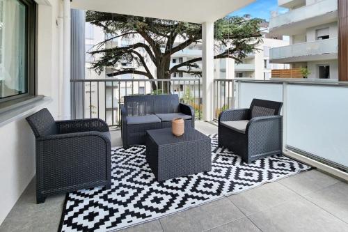 un patio avec des chaises et une table sur un balcon dans l'établissement Sous le cèdre, à Villeurbanne