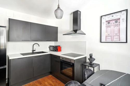 une cuisine avec un évier et un plan de travail dans l'établissement Cosy Alsace, à Villeurbanne