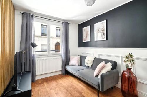 un salon avec un canapé et une télévision dans l'établissement Cosy Alsace, à Villeurbanne