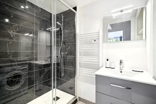 une salle de bain avec douche et lavabo dans l'établissement Cosy Alsace, à Villeurbanne