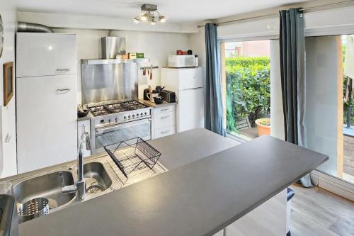 une cuisine avec un comptoir et des appareils en acier inoxydable dans l'établissement Oasis Citadine, à Villeurbanne