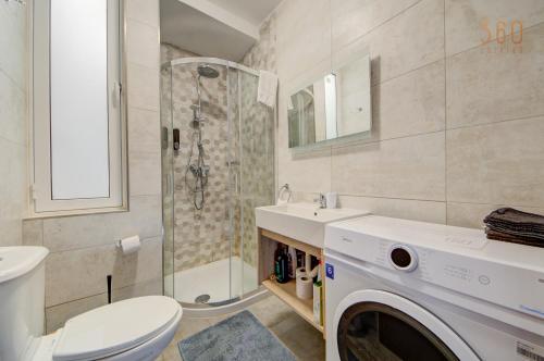 a bathroom with a toilet sink and a washing machine at Penthouse in Mosta with city views & terrace by 360 Estates in Mosta