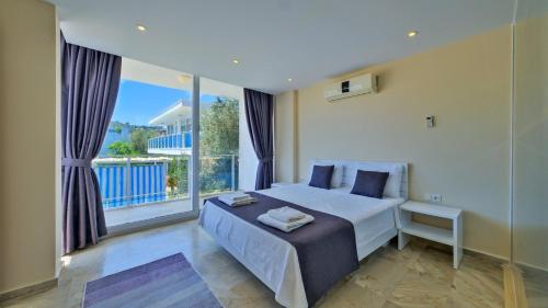 a bedroom with a bed and a large window at Kalkan 4 Bedroom Villa 6630 in Kalkan