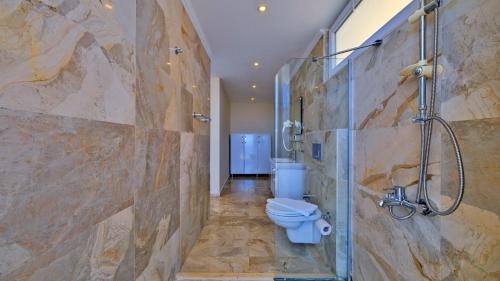 a bathroom with a toilet and a glass shower at Kalkan 4 Bedroom Villa 6630 in Kalkan
