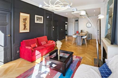un salon avec un canapé rouge et une table dans l'établissement Place Carnot, à Lyon