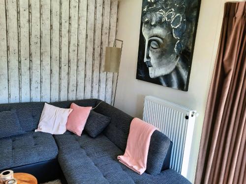 a living room with a blue couch with pink pillows at Veluwe Happy Together in Epe