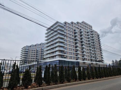 a tall white building with trees in front of it at Residence Lux apartman in Niš