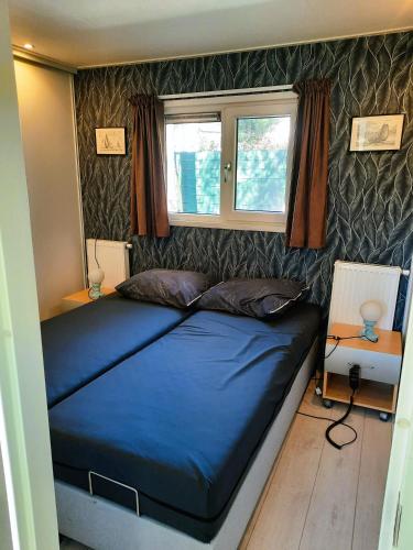 a bedroom with a blue bed in a room at Veluwe Happy Together in Epe