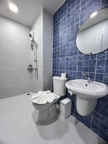 a blue tiled bathroom with a toilet and a sink at Kata walk&wave hostel in Kata Beach