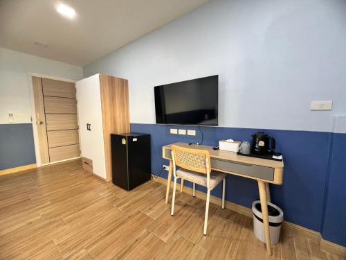 a room with a desk and a tv on a wall at Kata walk&wave hostel in Kata Beach