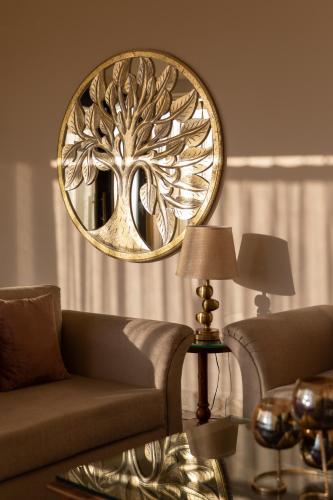 a living room with a couch and a mirror at Hotel Alaya in Dehradun