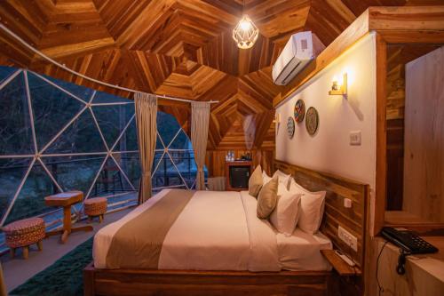 a bedroom with a bed in a tree house at Harness Zipline And Adventure Resort in Kusma