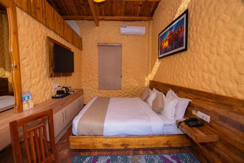 a bedroom with a bed and a television in it at Harness Zipline And Adventure Resort in Kusma