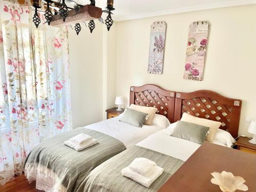 een slaapkamer met 2 bedden en een tafel bij Apartamento Cimadevilla 22 in Gijón