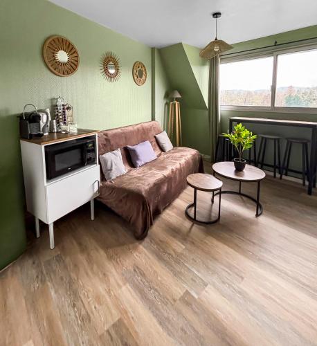 un salon avec un canapé et une table dans l'établissement Séjour paisible avec vue imprenable sur le Golf-self check-in, à Houlgate