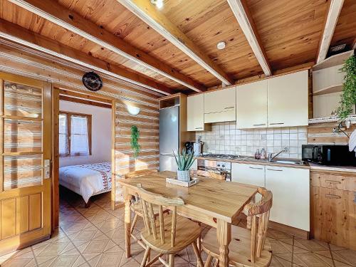une cuisine avec une table et des chaises en bois et une chambre dans l'établissement La Parenthèse de la Meuse, à Sauvigny