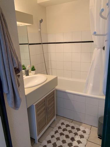 une salle de bain avec un lavabo et une baignoire dans l'établissement Appartement Cosy Hypercentre vue sur les montagnes, à Font-Romeu-Odeillo-Via