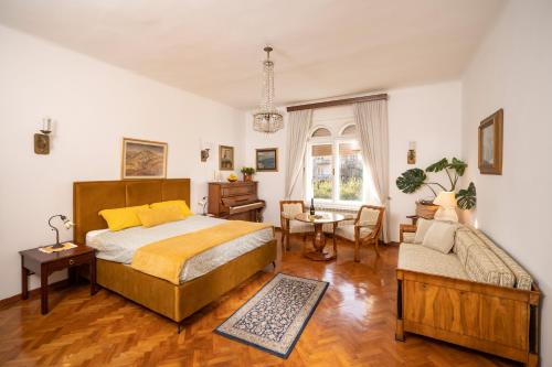 une chambre avec un lit, une chaise et une table dans l'établissement Villa Artur heritage - Luxury apartment, à Rijeka