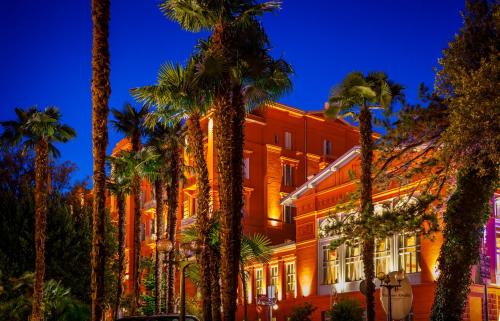 a building with palm trees in front of it at Hotel Imperial - Liburnia in Opatija