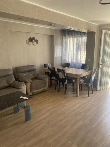 un salon avec un canapé, une table et des chaises dans l'établissement Belle maison bord de la mere Canet, à Canet