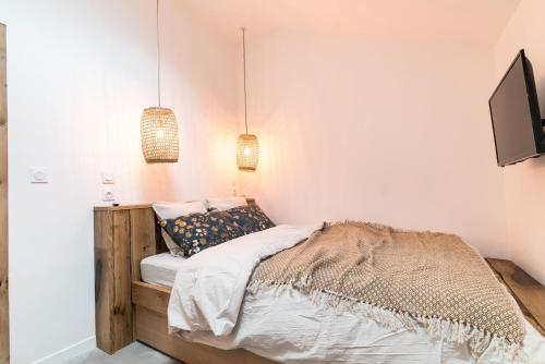a bedroom with a bed and two pendant lights at Gîte la Thébaide entière - Les Pittoresques in Saint-Jean-Saint-Maurice-sur-Loire