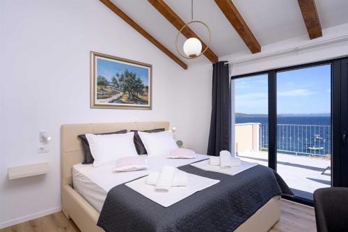 ein Schlafzimmer mit einem Bett und einem großen Fenster in der Unterkunft Villa Dolce Vita in Ivan Dolac