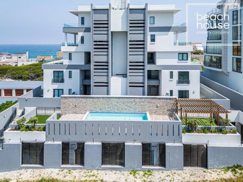 an aerial view of a building with a swimming pool at Luxury Beachfront Penthouse, Blouberg- 3 Bedroom in Bloubergstrand
