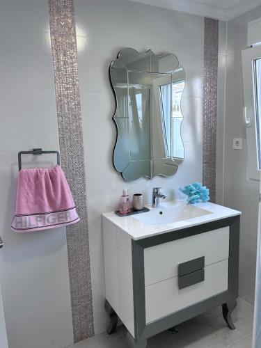 a bathroom with a sink and a mirror at Casa Mazagón con vistas al mar in Mazagón