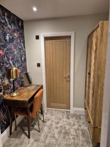 a room with a wooden desk and a door at The Resolution Hotel in Whitby