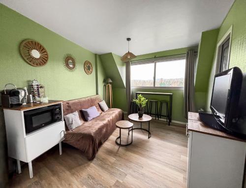 un salon avec un canapé et une télévision dans l'établissement Séjour paisible avec vue imprenable sur le Golf-self check-in, à Houlgate