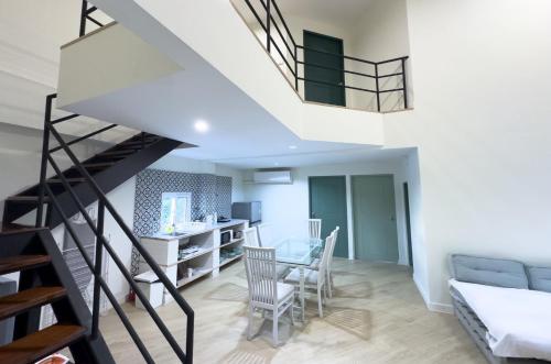 a staircase in a living room with a table and chairs at Baan Khun Pra Duplex Rm3 Bangkok in Bangkok