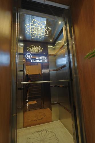 a glass elevator door with a sign on it at AJMER TERRACES Hotel in Ajmer