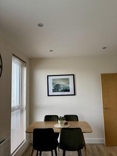 a dining room table with chairs and a picture on the wall at Modern spacious apartment in Addlestone in Addlestone