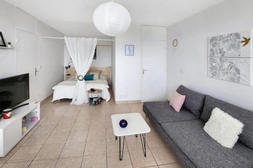 un salon avec un canapé et un lit dans l'établissement City View, à Villeurbanne