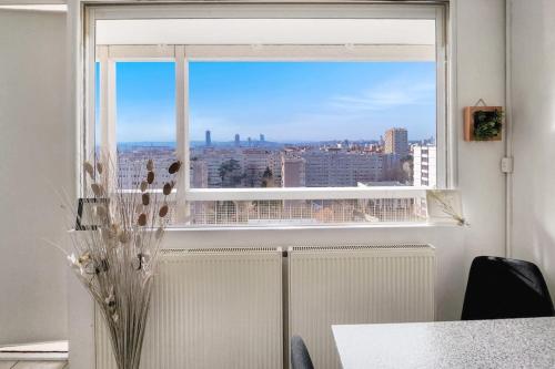 une fenêtre avec vue sur la ville dans l'établissement City View, à Villeurbanne