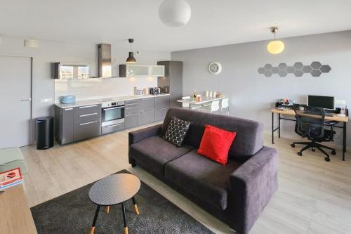 a living room with a couch and a kitchen at Confluence in Lyon