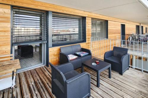 - une terrasse couverte avec 2 chaises et une table dans l'établissement Confluence, à Lyon