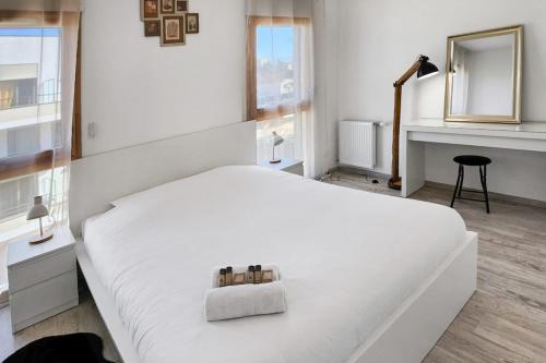 - une chambre blanche avec un lit blanc et un miroir dans l'établissement Cosy Arborea, à Bron