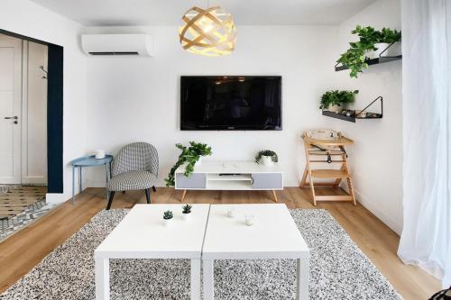 Il comprend un salon doté d'une table blanche et d'une télévision. dans l'établissement Eurexpo 3ch, à Bron