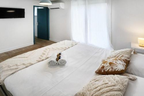 un grand lit blanc avec deux oreillers dessus dans l'établissement Villa Eurexpo 185m2, à Bron