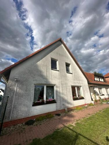 a white house with two windows and a roof at Apartmenthaus Iris&Jasmin in Friedrichshagen