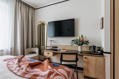 a hotel room with a bed and a desk with a computer at Colette - LoftAffair Collection in Warsaw