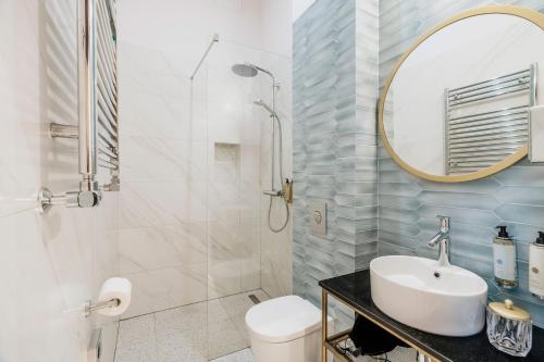 a bathroom with a sink and a toilet and a mirror at Colette - LoftAffair Collection in Warsaw