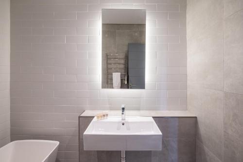 a bathroom with a sink and a toilet and a mirror at Luxury Beachfront Penthouse, Blouberg- 3 Bedroom in Bloubergstrand