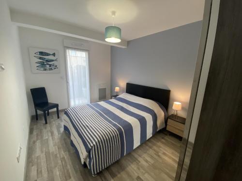 une chambre avec un lit, une chaise et une fenêtre dans l'établissement Les Roses Appartement 3 etoiles, à Les Sables-dʼOlonne
