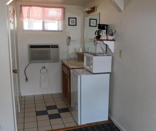a small kitchen with a refrigerator and a microwave at Barewood Inn & Suites in Wofford Heights