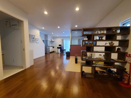 a living room with wooden floors and a wooden shelf at Cottage SORA in Onna