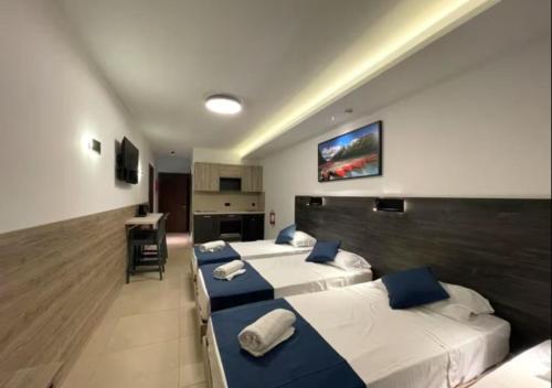 a hotel room with two beds and a kitchen at Bayside A Apartments in St Julian's