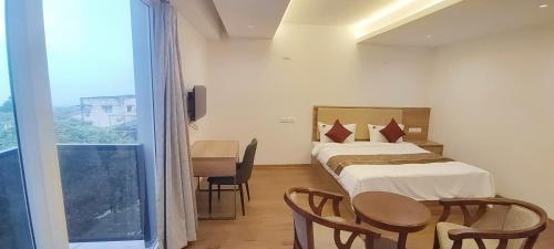 a hotel room with a bed and a table and chairs at Spring Valley Enclave in Kodaikānāl